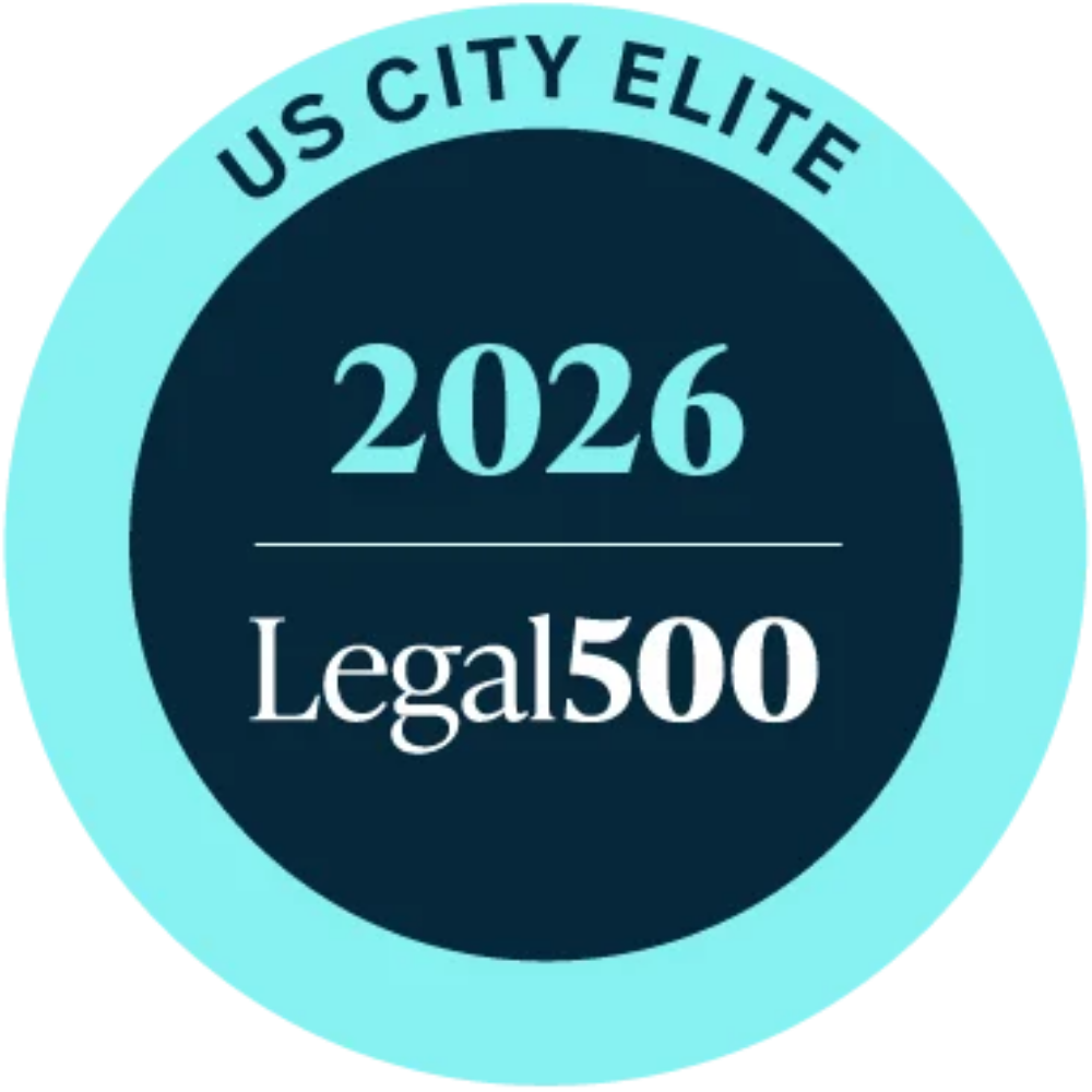 Circular badge with teal border and dark center reading ‘US City Elite 2026’ and ‘Legal500’ in white text.