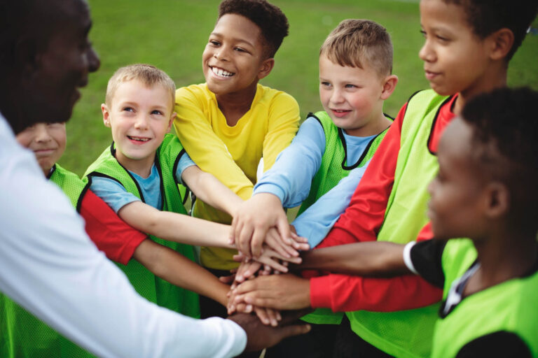 Junior soccer team stacking hands before a match